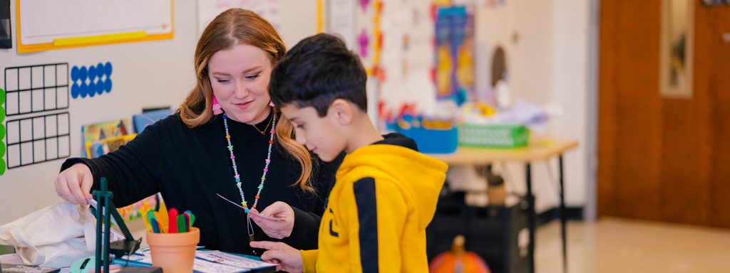 UNCG student teacher Amanda Best works an elementary student.