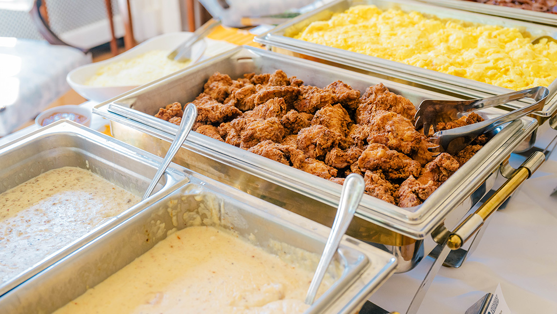 Trays full of fried chicken and sides.