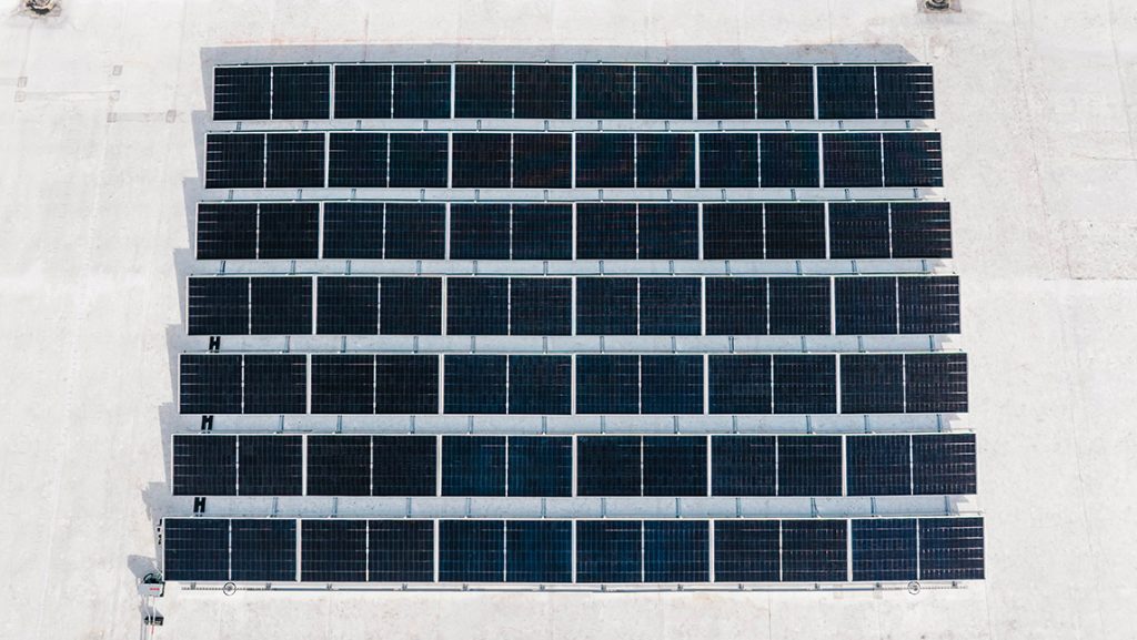 Workers install solar panels on UNCG Middle College roof.