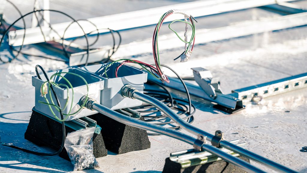 Workers install solar panels on UNCG Middle College roof.