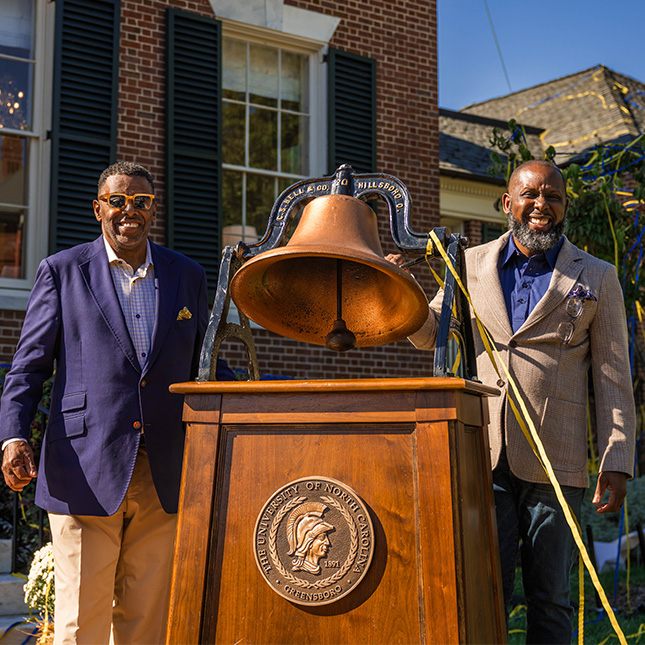 Chancellor Gilliam and Marcus T. Johnson ring the bell at the Alumni House naming.