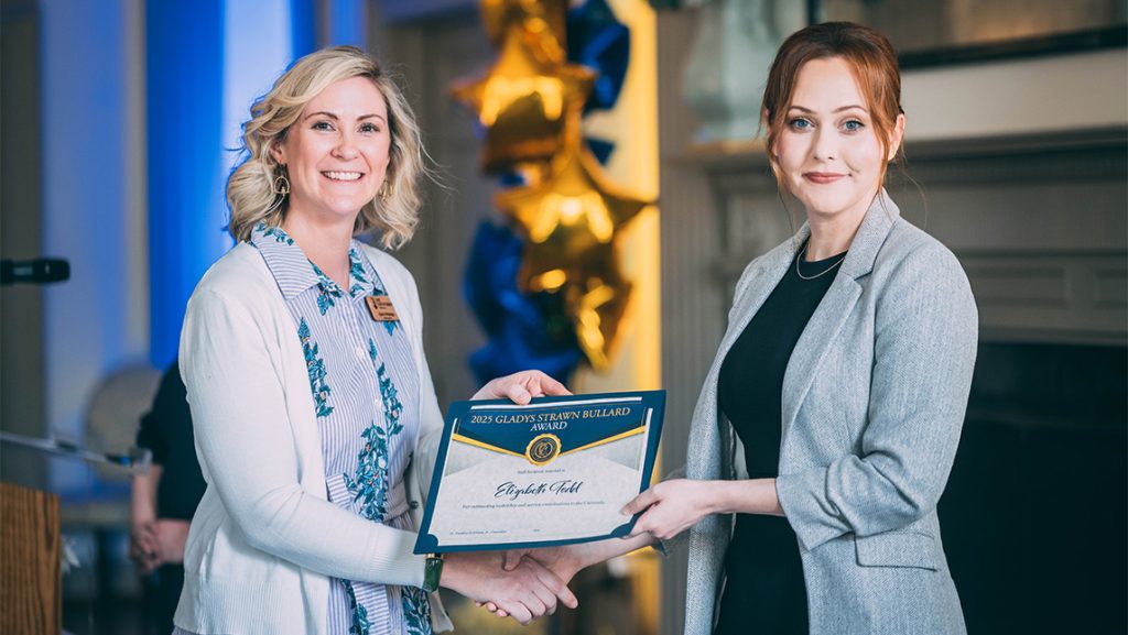 UNCG's Clara Hidalgo hands Beth Todd an award.