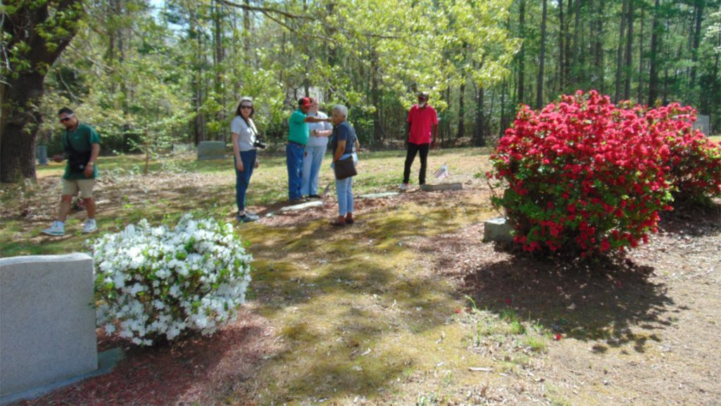 People walk around Strieby Cemetery.