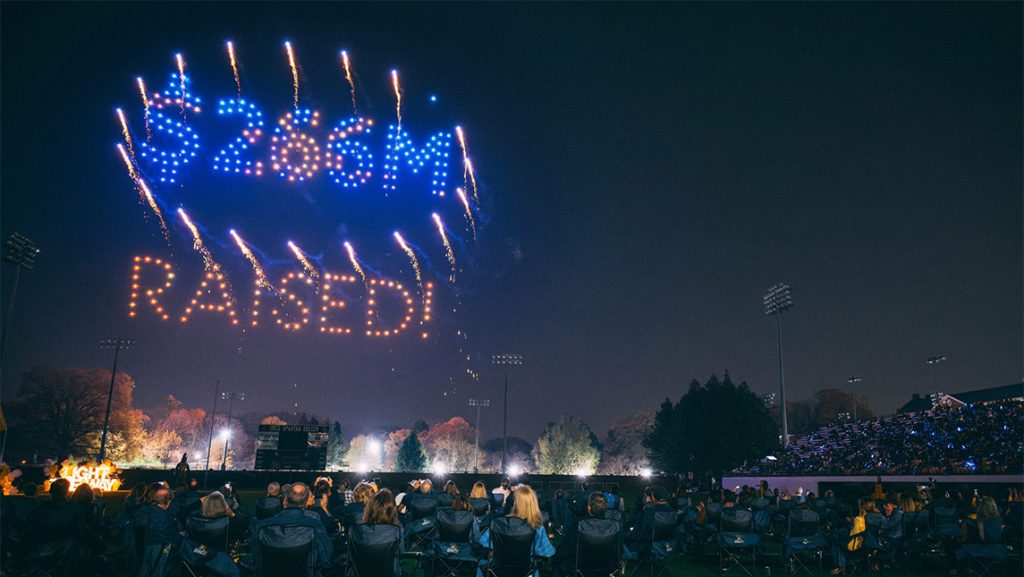 Drone light show over UNCG reads "$266M raised."