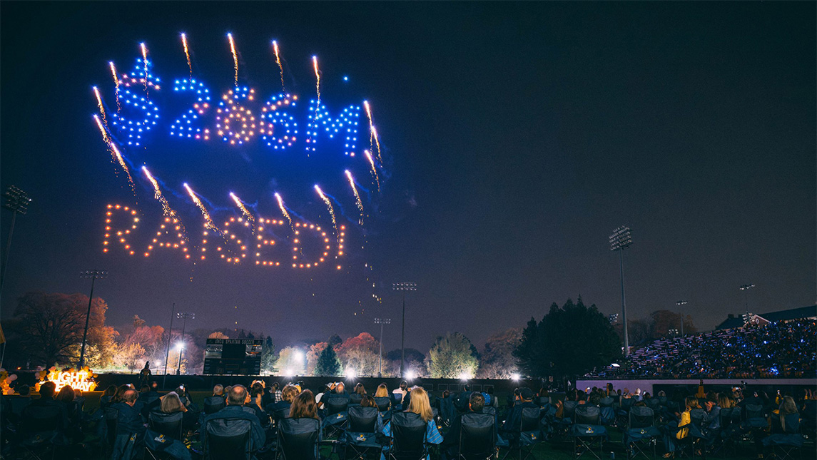 Drone light show over UNCG reads 