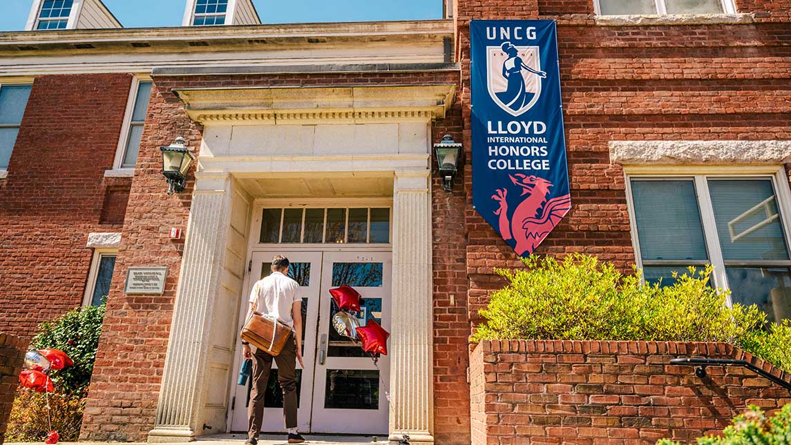 as student walks up the steps to a building