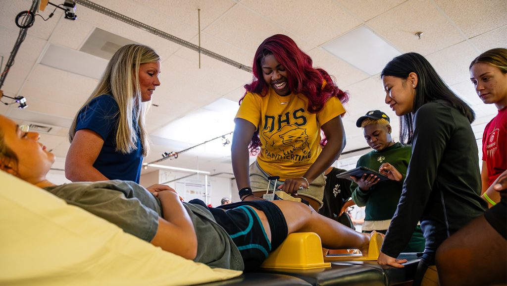 Kinesiology students work in the lab to stabilize a patient's knee.