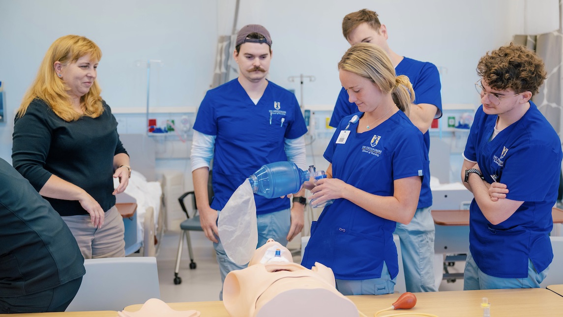 UNCG School of Nursing students learning in the classroom with AI stimulation and practice mannequins.