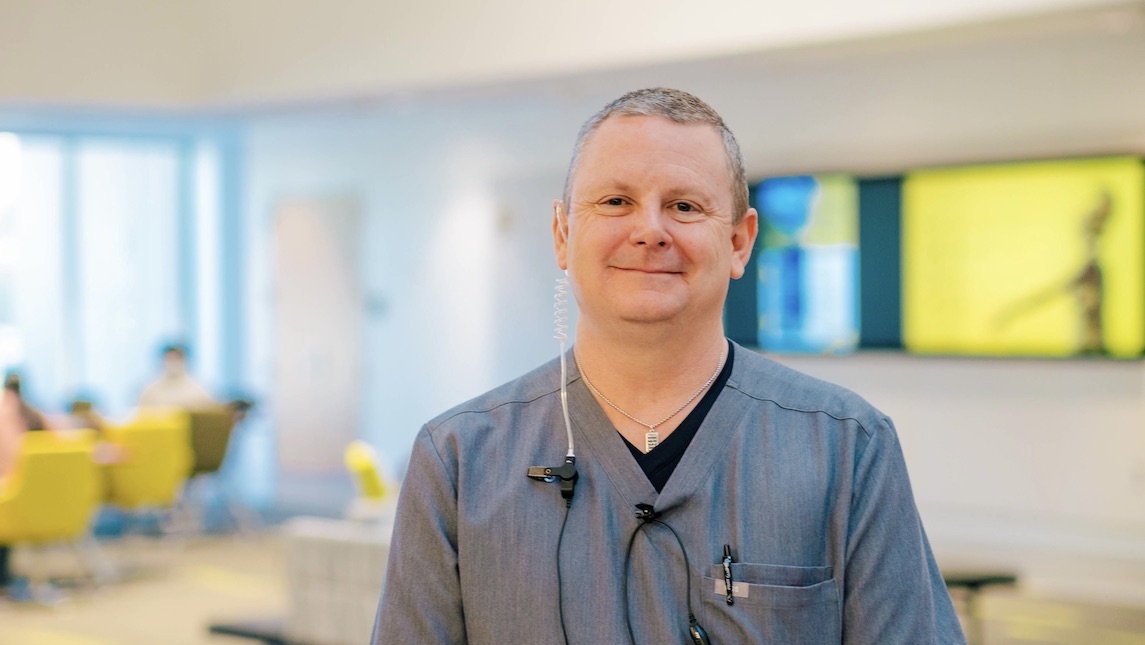 UNCG School of Nursing professor Tommy Mann stands in one of the classrooms that uses AI stimulation as a tool for students.