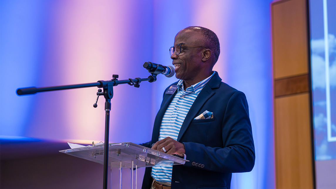 UNCG Dr. Brett Carter speaks at a podium.