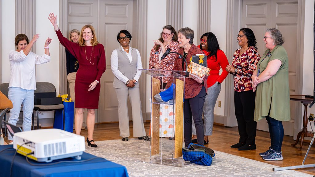 CYFCP staff gather around a podium.