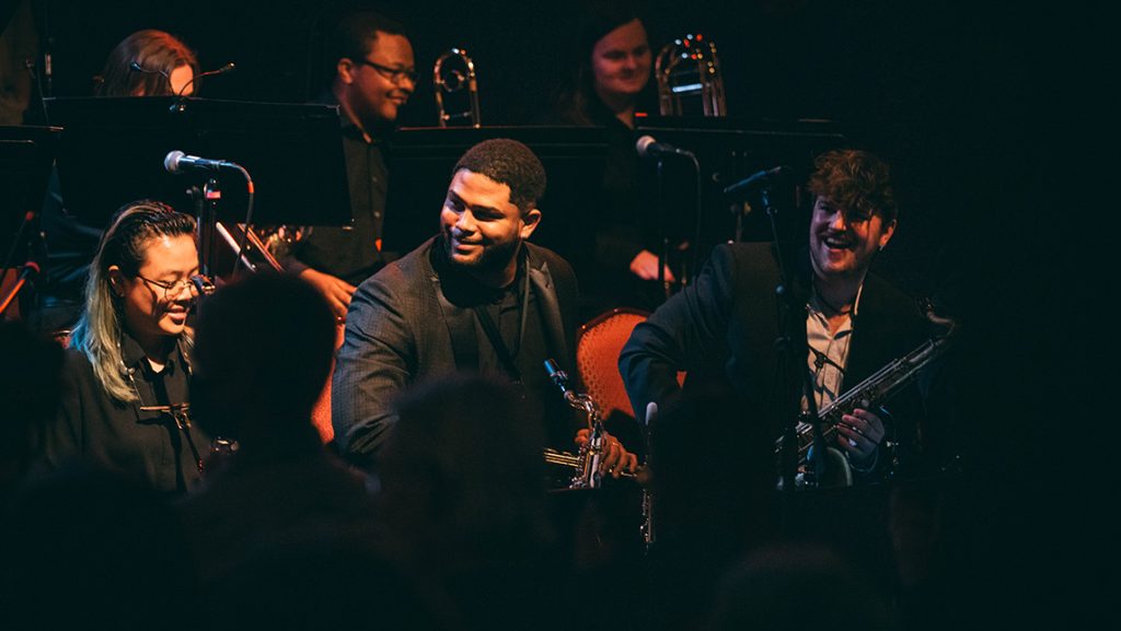 Franco Romero smiling along with fellow UNCG jazz students.