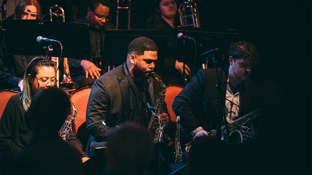 UNCG student Franco Romero onstage playing his saxophone.