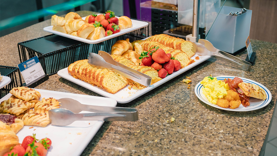 Trays full of breakfast foods, fruits, and desserts at UNCG.