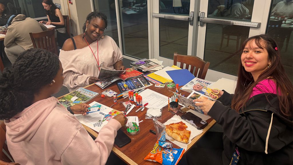 UNCG students around a table doing activities.