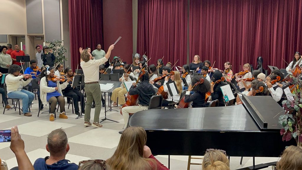 A conductor leads student musicians in rehearsal at UNCG.