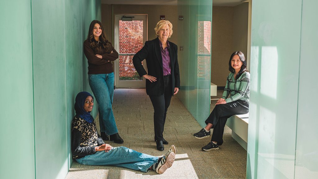 UNCG's Dr. Susan Keane with students in the hallway.