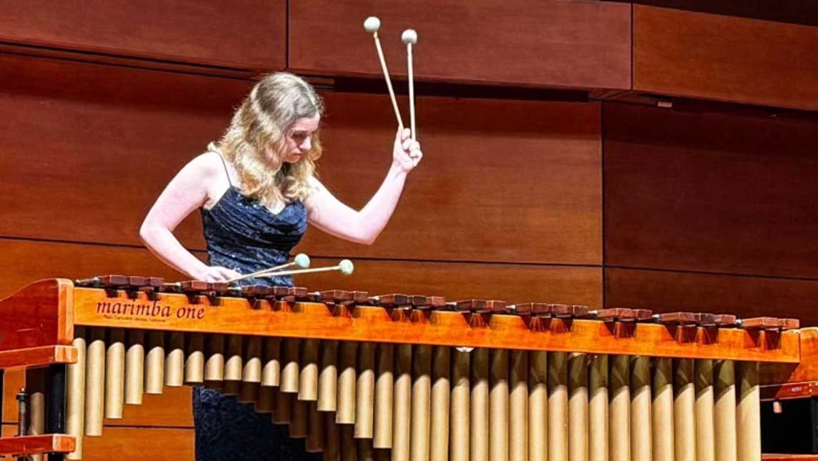 a woman plays a zylophone