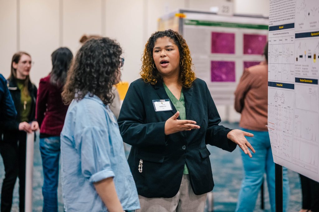 Students present their research posters to expo attendees
