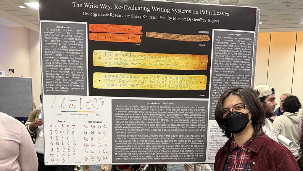 Sheza stands in front of his poster