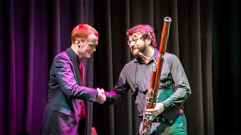 UNCG's Dr. Ryan Reynolds shakes hands with Cameron Garris ’19 BM.