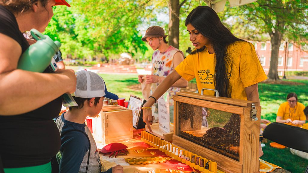 Bee Campus members show children a hive.