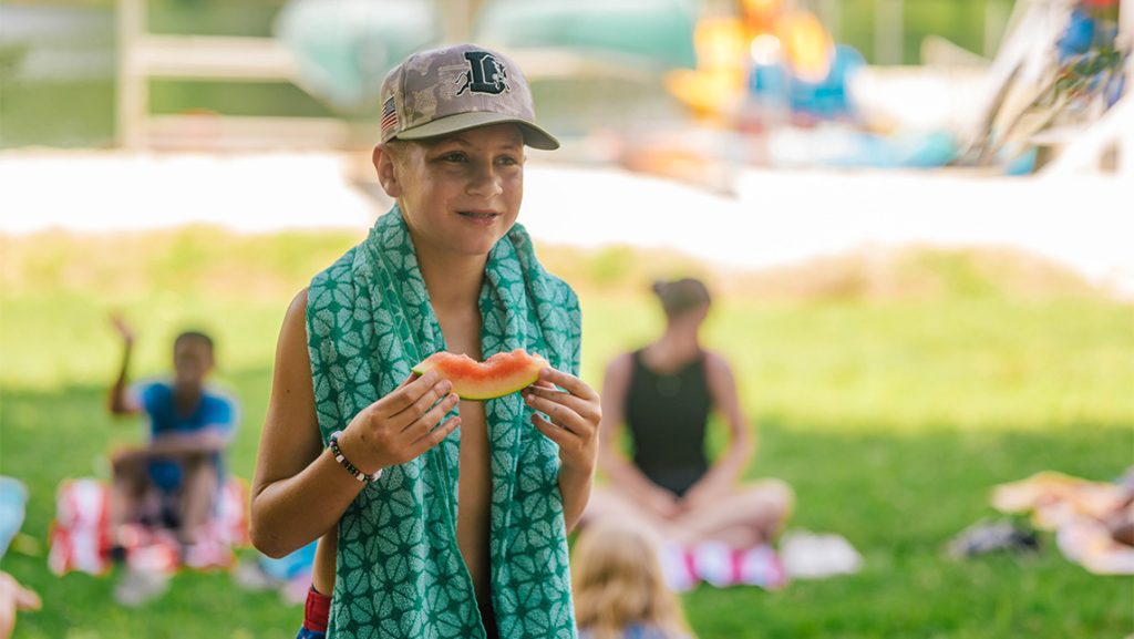 A boy eats watermelon at Piney Lake.