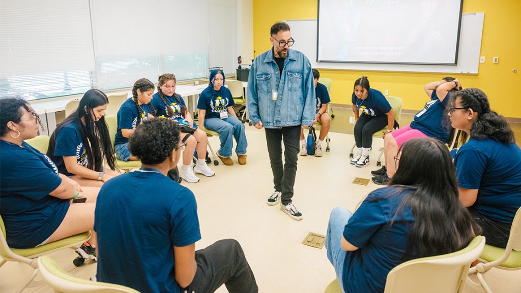 A UNCG professor talks to high school students in a classroom.