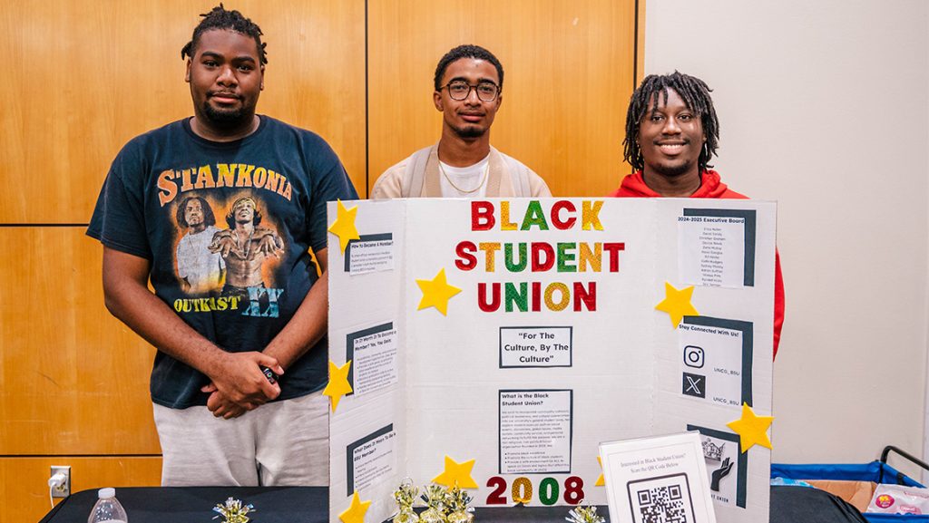 UNCG students behind a posterboard promoting Black Student Union.