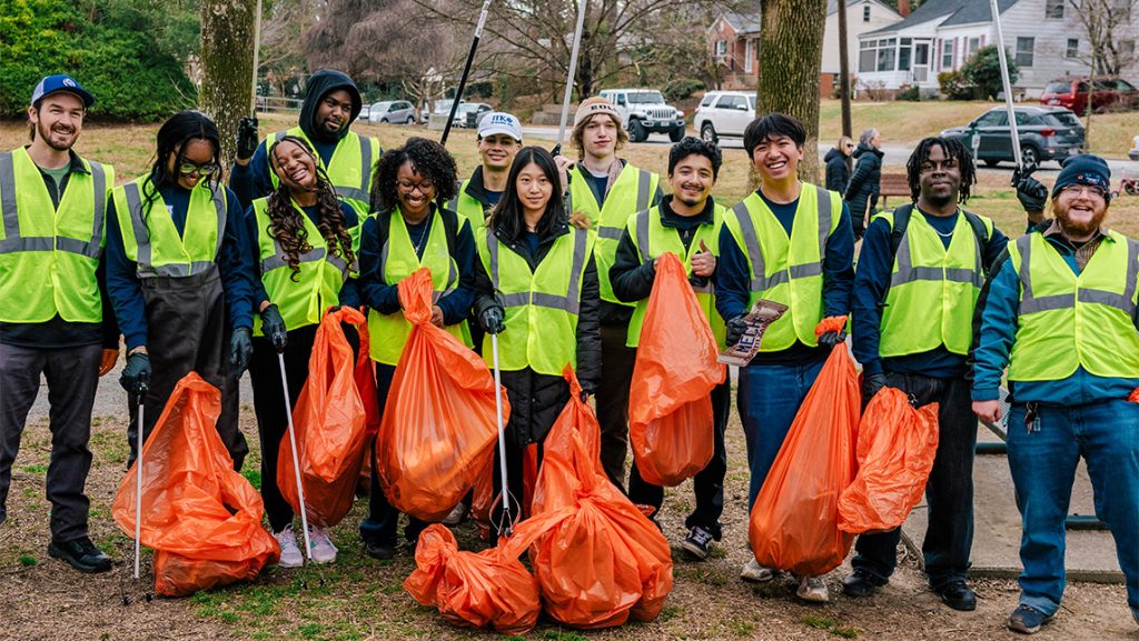 David Sandy with a group of students in reflective vests and trash bags.