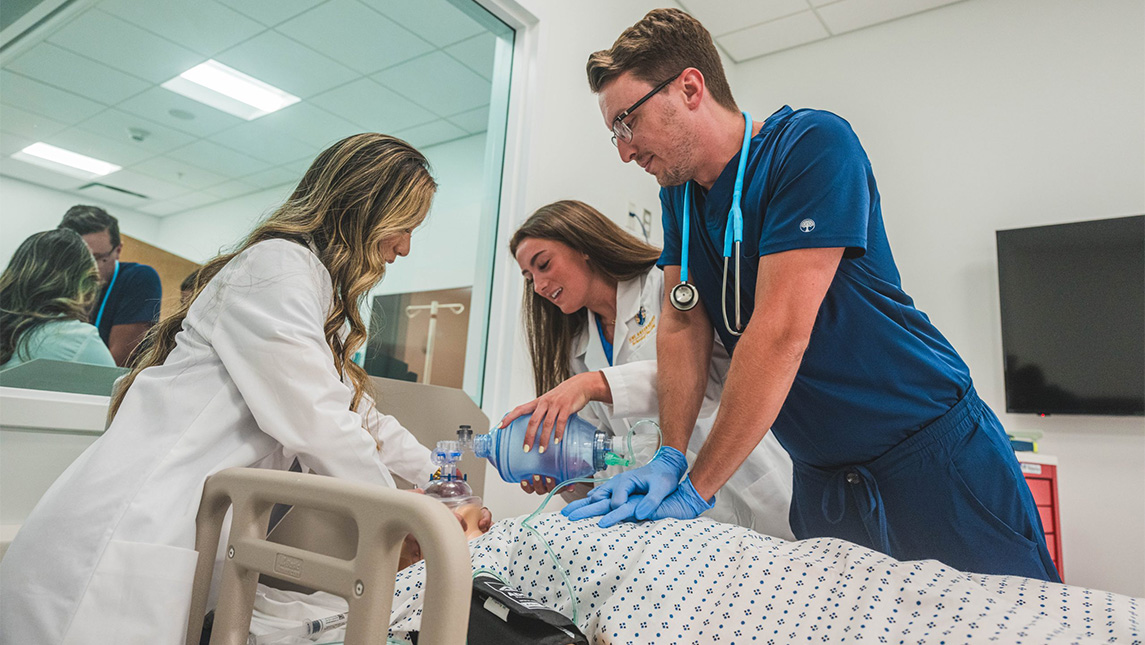 Huong Thuy Ka’24, Lyndsey Dark ’24, and Zack Wiggins ’25, conduct nursing with a manikin in a hospital bed.