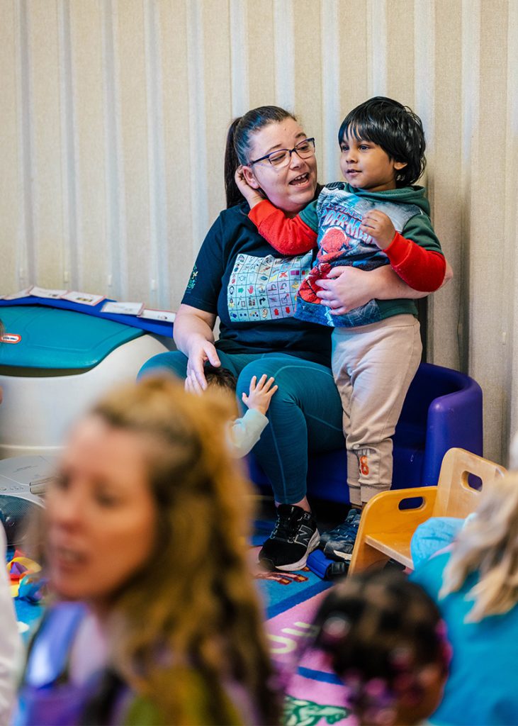 A GCPA classroom lead sings with a little boy.