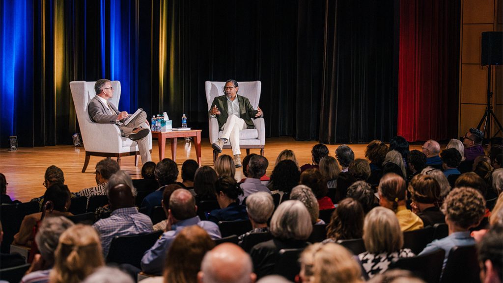 Author Percival Everett on the stage talking to a crowd in UNCG Auditorium.