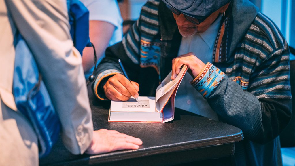 Author James McBride autographs a book.