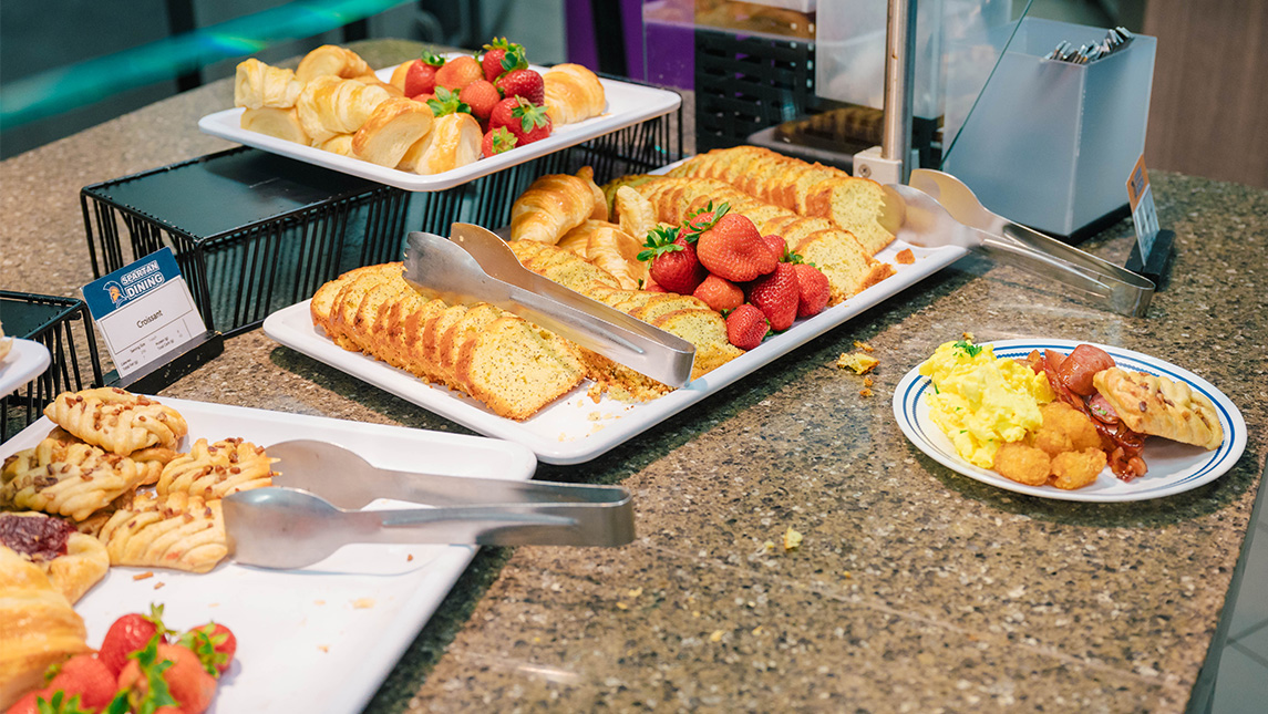 Platters full of breakfast foods.