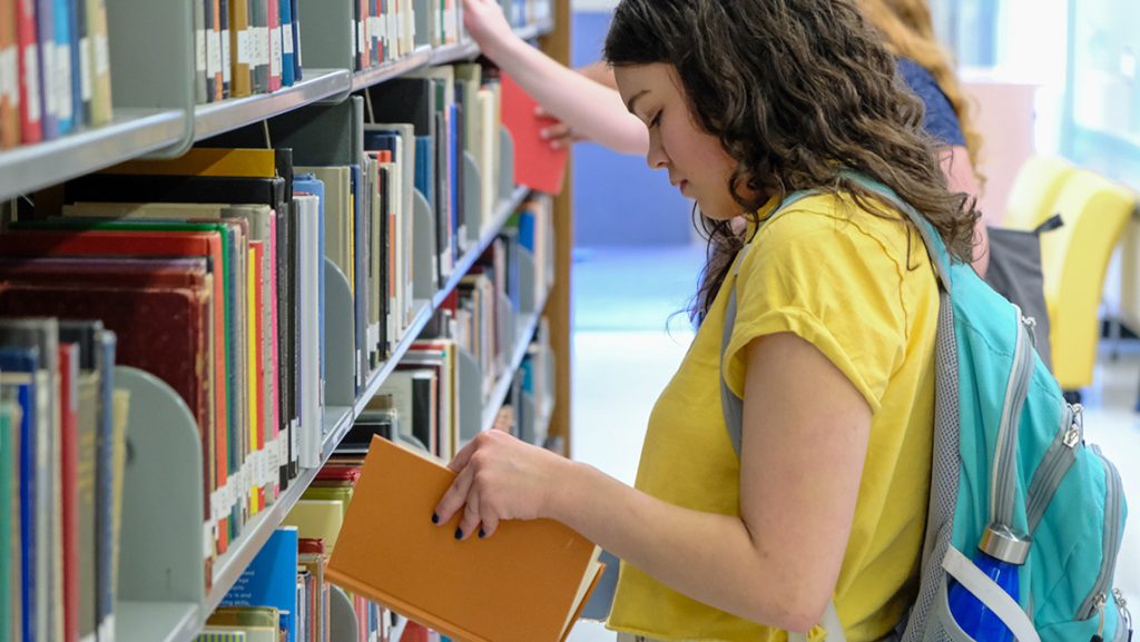 UNCG students look at books in the library.