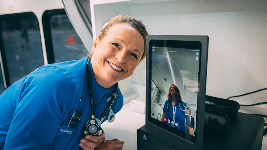 UNCG Nursing Professor Sarah Apel stands next to teledoc tablet.