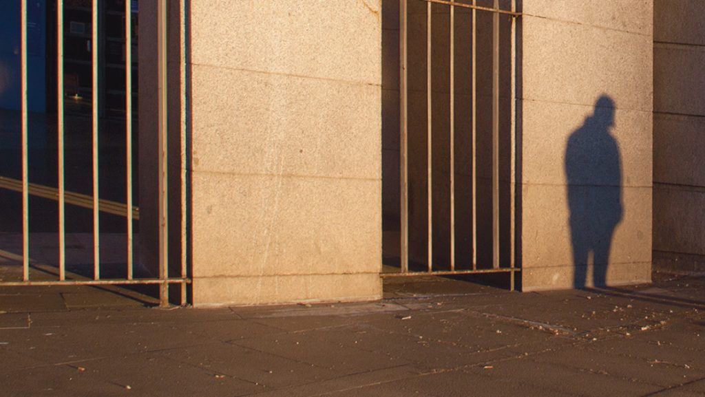 Cover of International Poetry Review depicts a man's shadow on a wall.