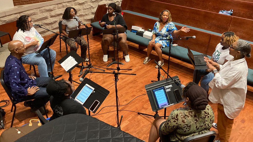 UNCG students sing in a circle with Professor Janinah Burnett and Precious D. Lovell.