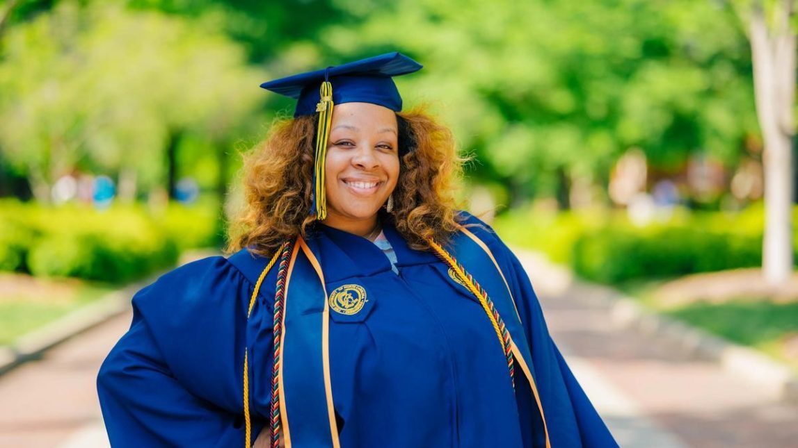Naima Blakely wearing her UNCG cap and gown.