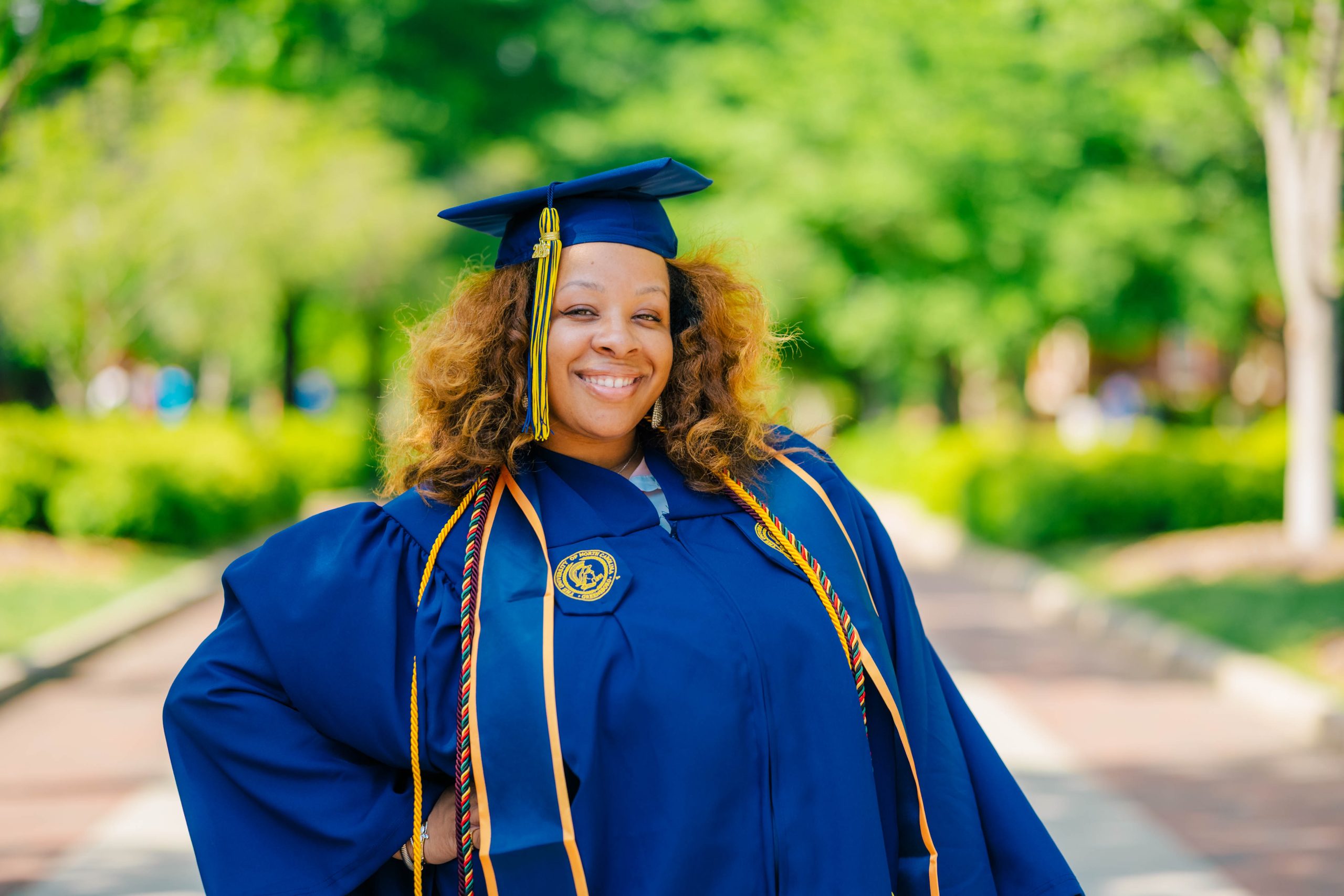 Naima Blakely wearing her UNCG cap and gown.