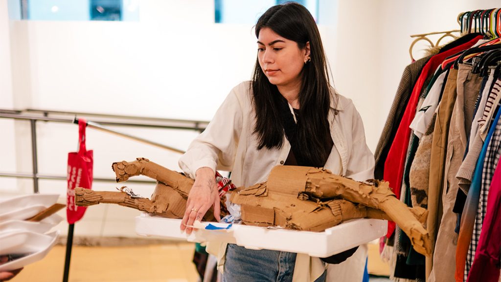 Student Sofia Aguilar walks holding art supplies.