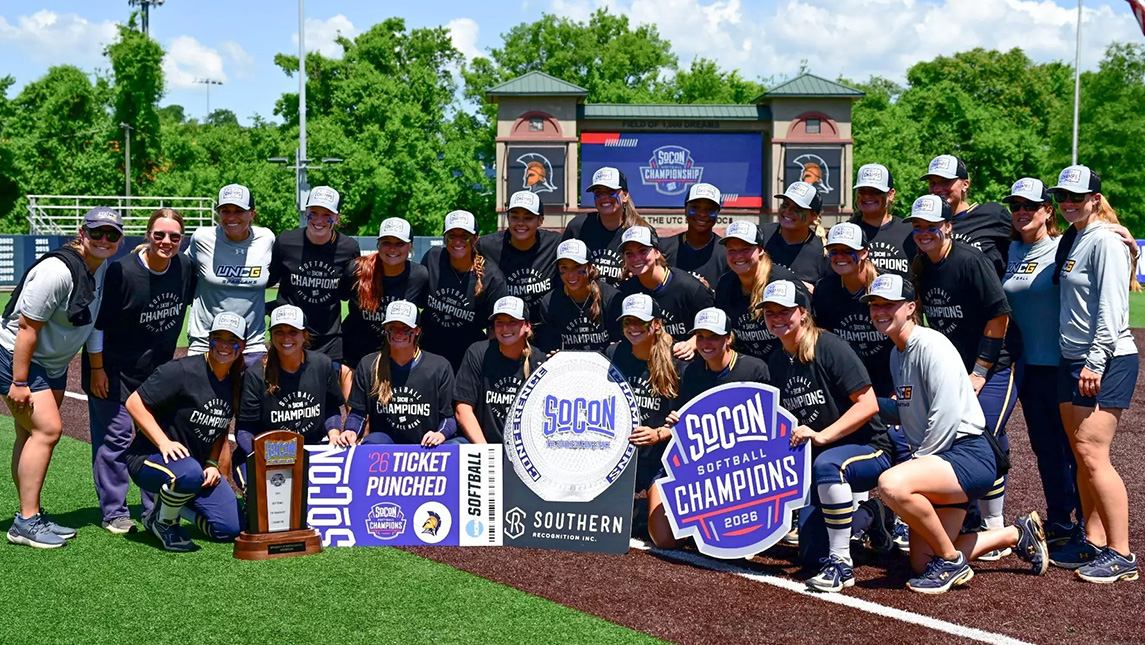 UNCG softball team poses on the field with their SoCon tournament champion ticket.