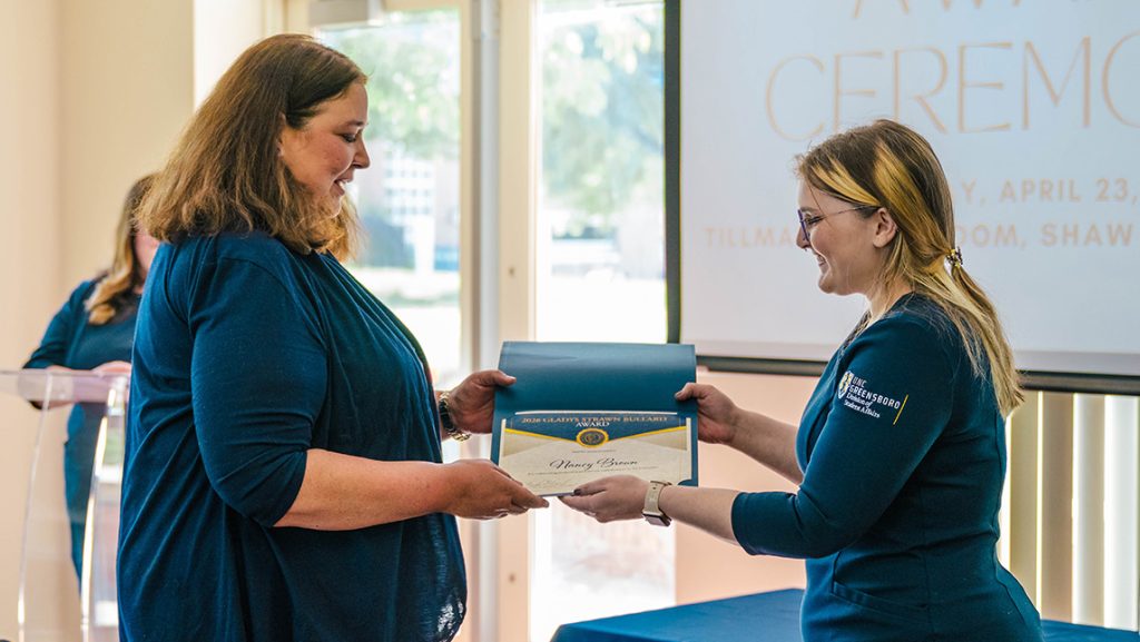 Mary Steele gives Nancy Brown a certificate.