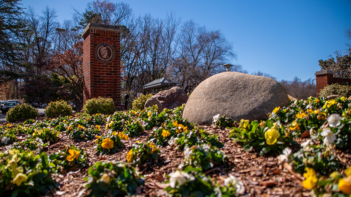 Landscaping beside the UNCG seal.