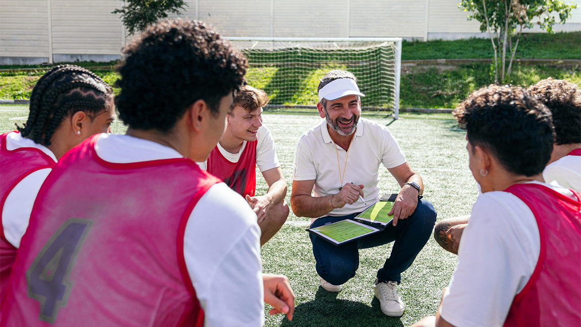 Coach with team on soccer field