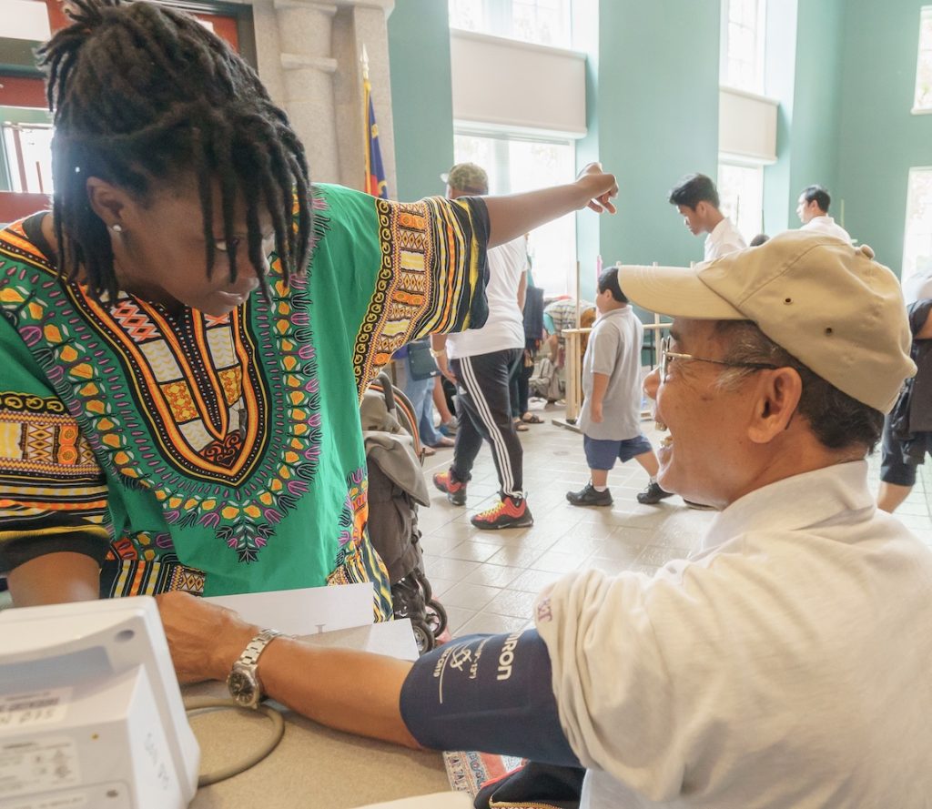 A woman takes a man's blood pressure.