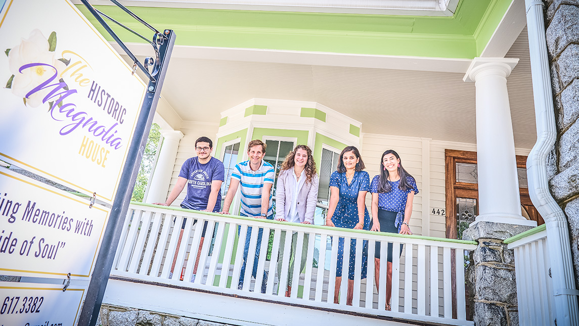 Students and their professor Asha Kutty look out from the porch of Greensboro's Magnolia House.
