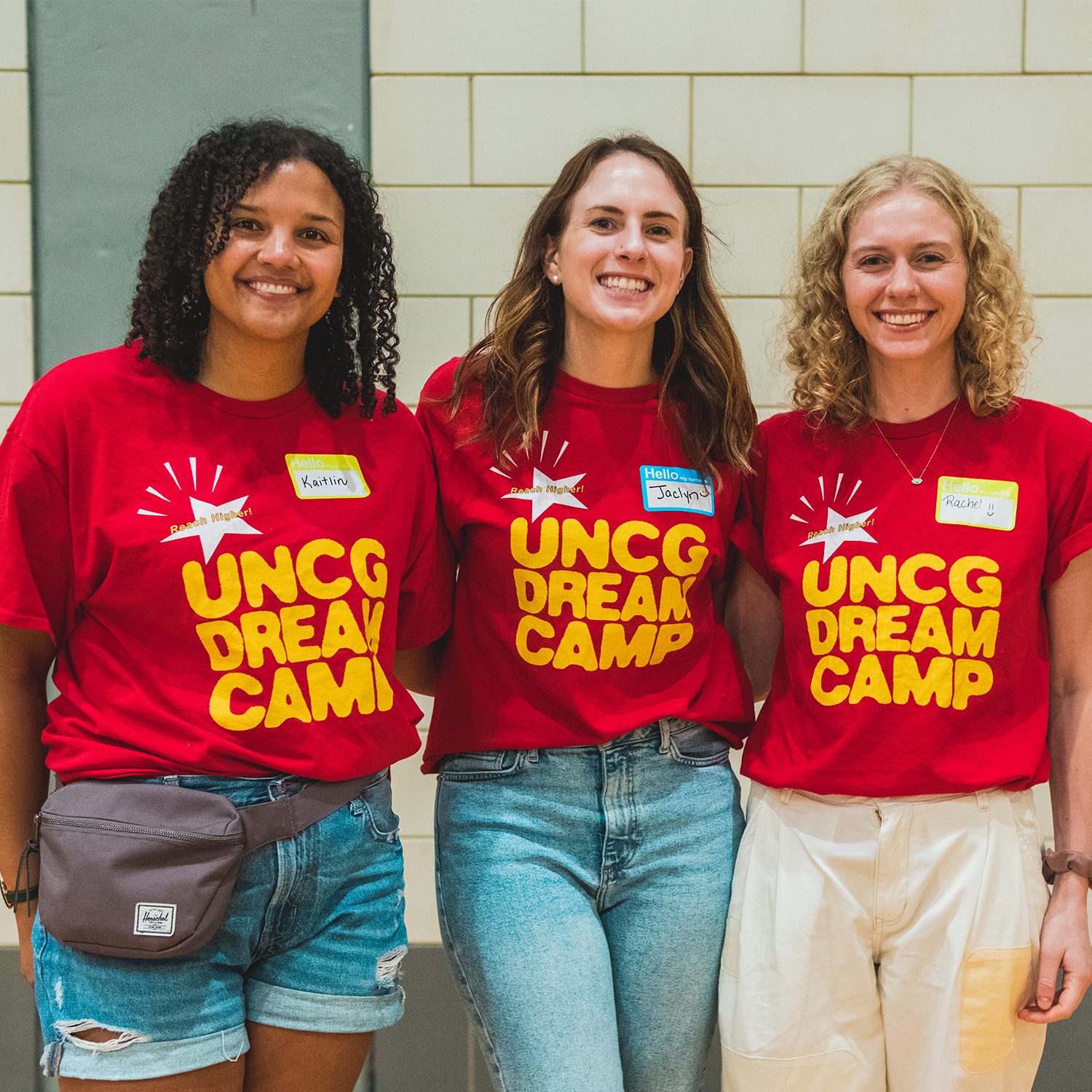 Three female counselors wearing Dream Camp shirts.