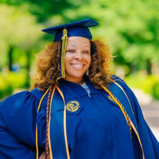 Naima Blakely wearing her UNCG cap and gown.